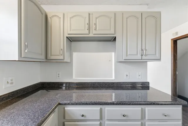 a kitchen with granite countertop white cabinets and a stainless steel appliances
