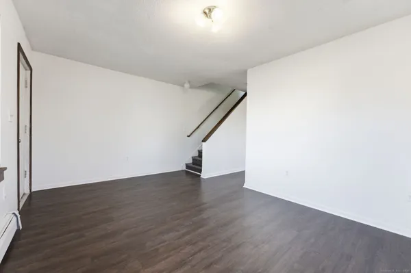 a view of an empty room with wooden floor