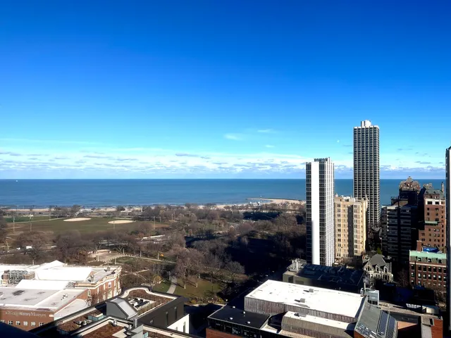 a view of an empty room with wooden floor and a fireplace