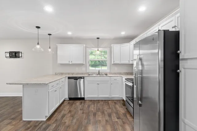 a kitchen with a refrigerator and white cabinets