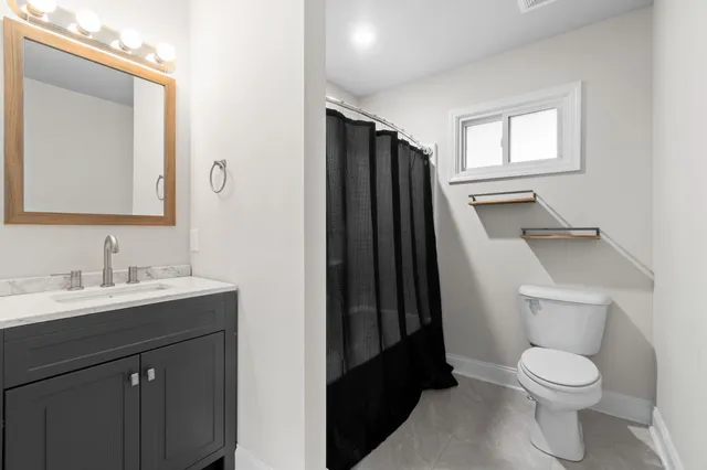 a bathroom with a toilet sink and mirror