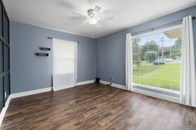 an empty room with wooden floor and a window