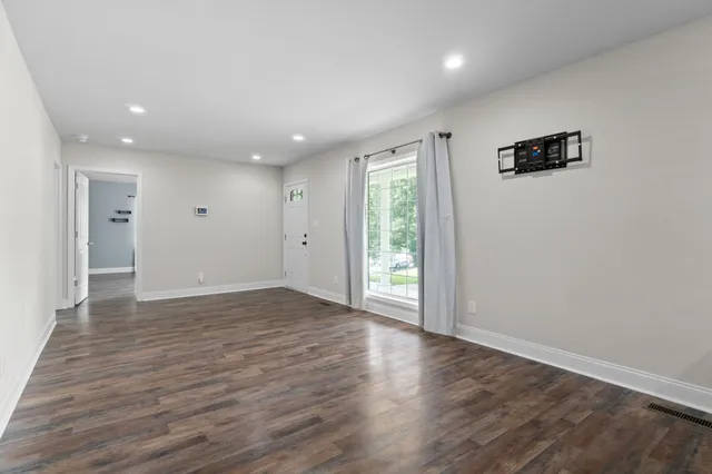 a view of empty room with wooden floor