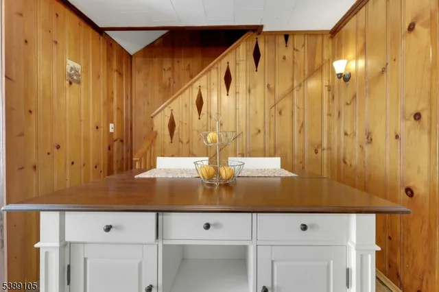 a view of kitchen with granite countertop white cabinets and a wooden floor