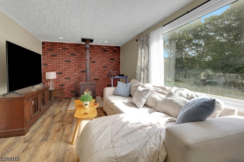 28 Risley Road West Milford, NJ 07421 - Photo 7 of 23 a living room with couches bookshelf and a flat screen tv