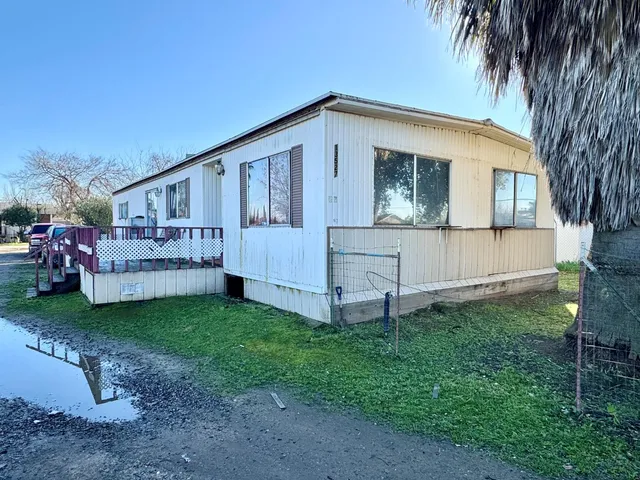 a view of a house with a yard and sitting area