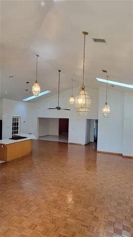 a view of a room with a sink wooden floor and a chandelier
