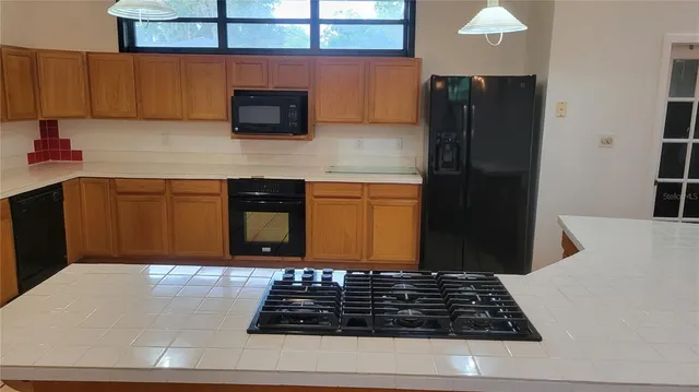 a kitchen with stainless steel appliances granite countertop a refrigerator and a stove