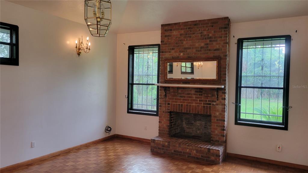 1014 Southeast 10th Street Gainesville, FL 32601 - Photo 8 of 16 an empty room with windows fire place and fireplace