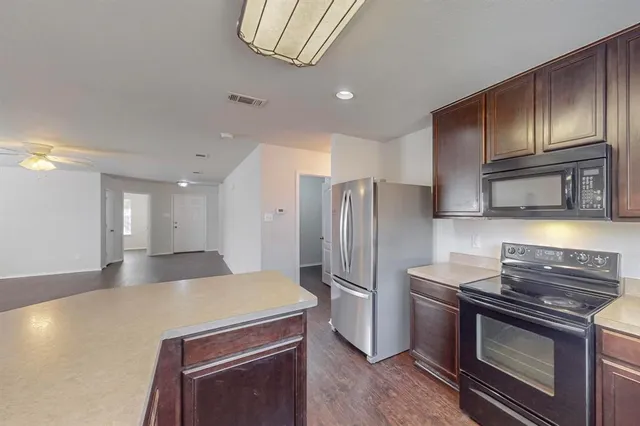 a kitchen with stainless steel appliances granite countertop a refrigerator stove and sink