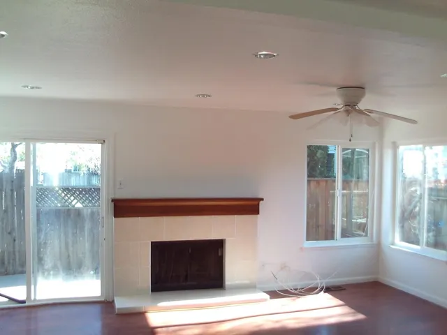 a living room with a fireplace and windows