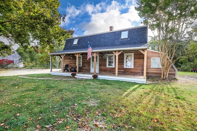 a view of a house with backyard and a tree