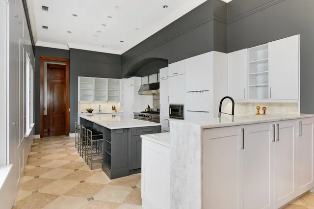 a large kitchen with stainless steel appliances a stove a sink and a refrigerator