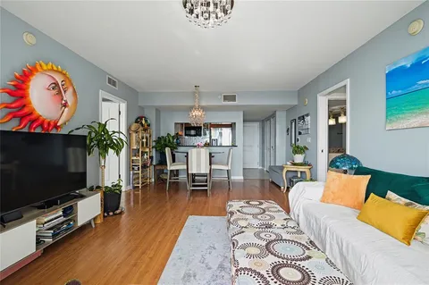 a living room with furniture a chandelier and a window
