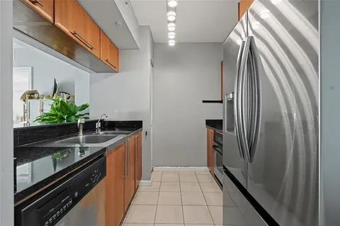 a kitchen with stainless steel appliances granite countertop a refrigerator and a sink