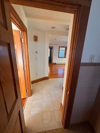 a view of a hallway and a livingroom with furniture