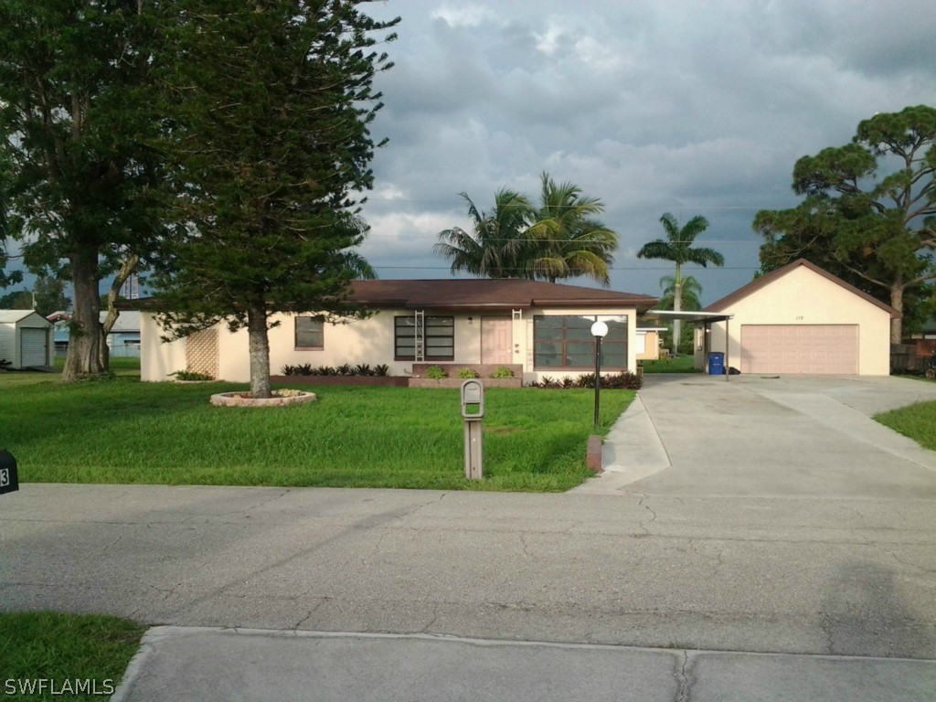 112 Florida Road Lehigh Acres, FL 33936 - Photo 1 of 25 a front view of house with yard and green space