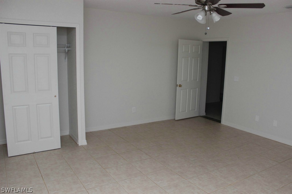 112 Florida Road Lehigh Acres, FL 33936 - Photo 20 of 25 an empty room with a ceiling fan and a window