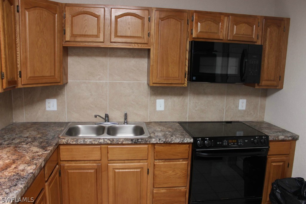 112 Florida Road Lehigh Acres, FL 33936 - Photo 5 of 25 a kitchen with granite countertop white cabinets and a stove top oven