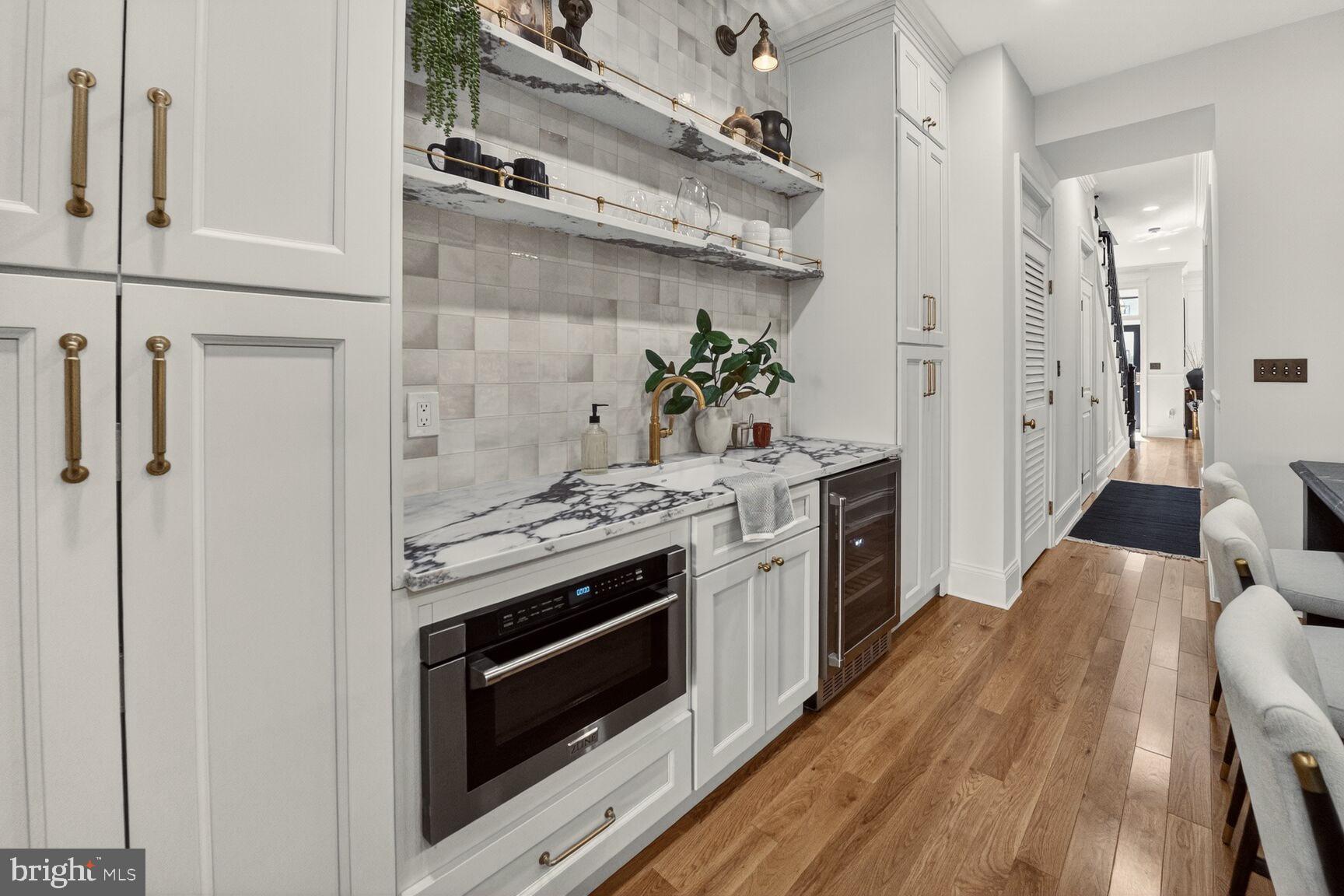 1203 T Street Northwest Washington, DC 20009 - Photo 20 of 46 a kitchen with stainless steel appliances wooden floor sink and wooden cabinets