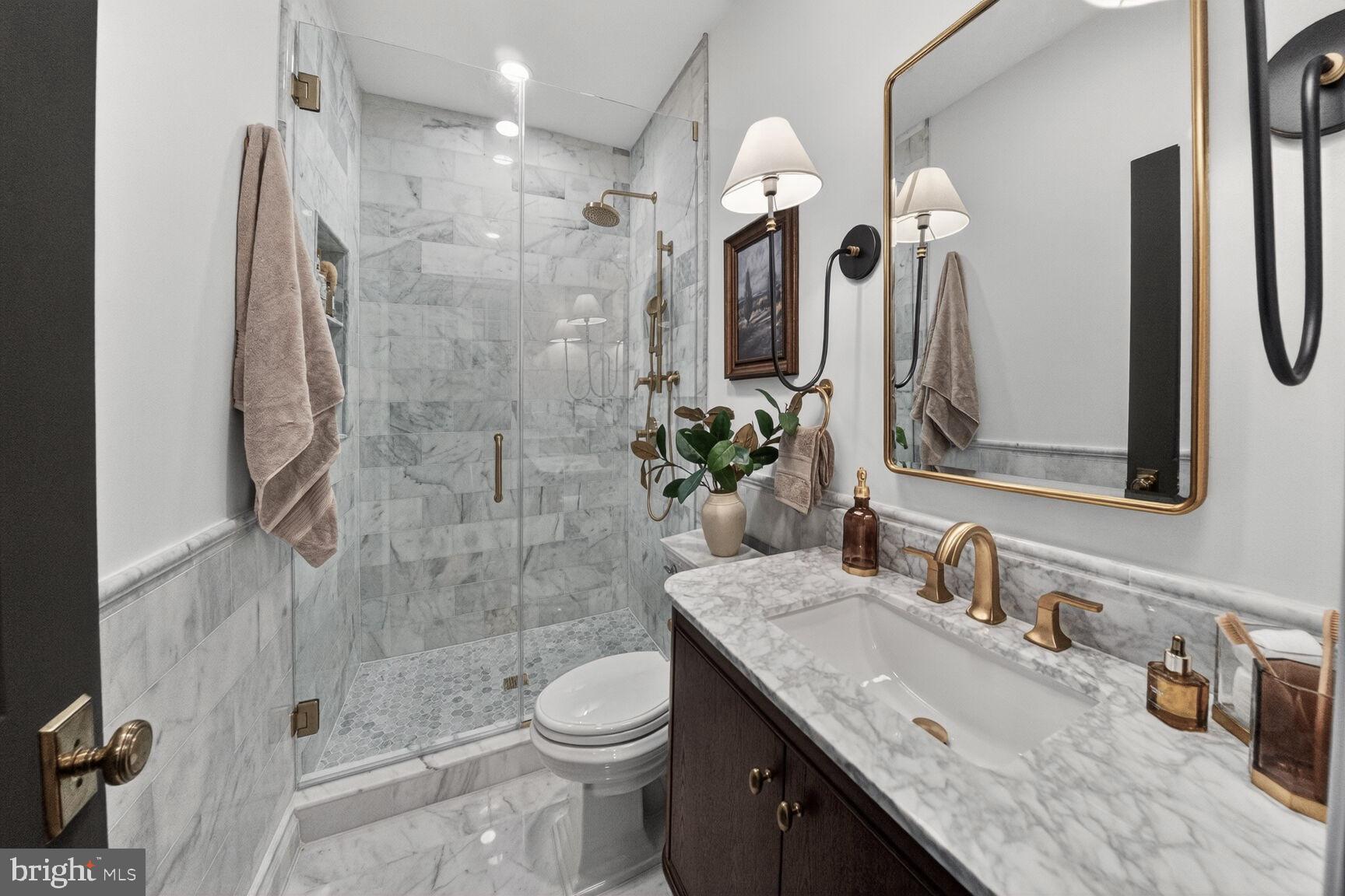 1203 T Street Northwest Washington, DC 20009 - Photo 42 of 46 a bathroom with a granite countertop sink a toilet a mirror and shower
