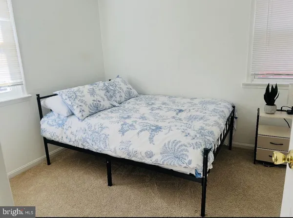 a bedroom with a bed chair and a window