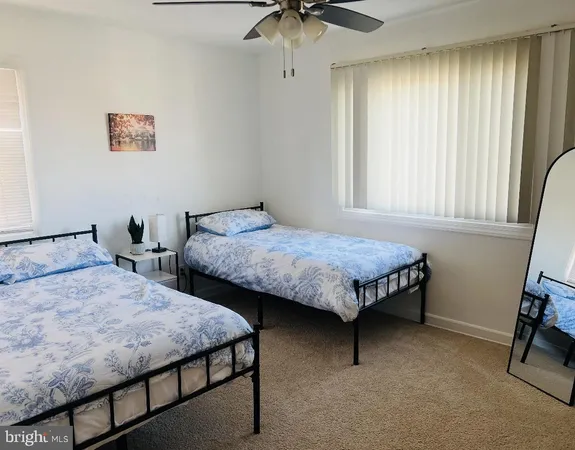 a bedroom with two beds and a desk