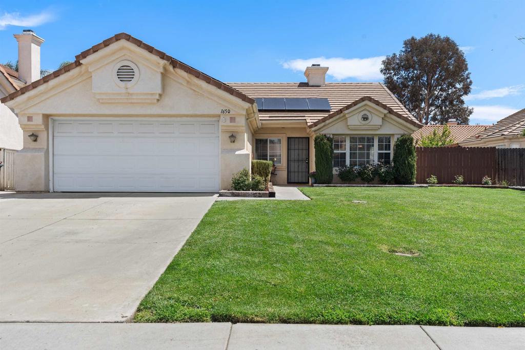 1650 Calathea Road Hemet, CA 92545 - Photo 1 of 1 a view of a white house with a yard and large tree