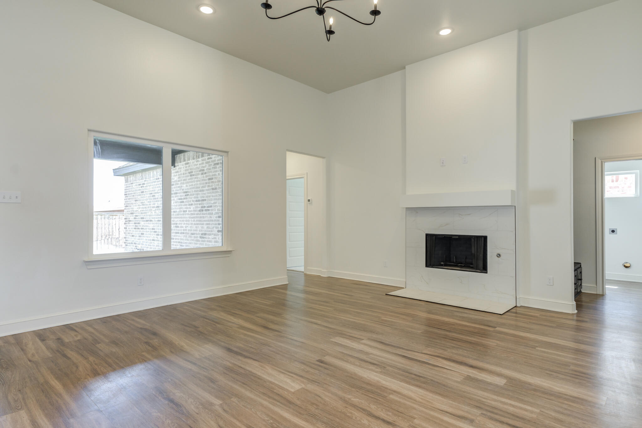 5720 119th Street Lubbock, TX 79424 - Photo 20 of 43 an empty room with windows and a fireplace
