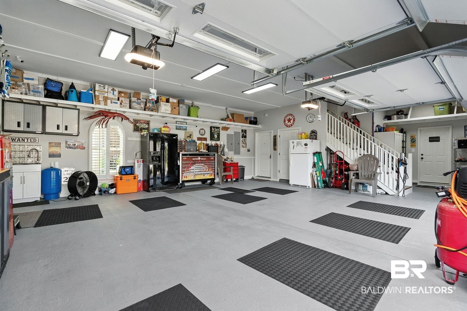 23357 Carnoustie Drive Foley, AL 36535 - Photo 81 of 99 Garage with freestanding refrigerator, a garage door opener, and a workshop area
