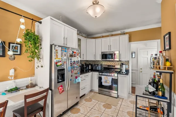 a kitchen with stainless steel appliances granite countertop a refrigerator and a stove top oven