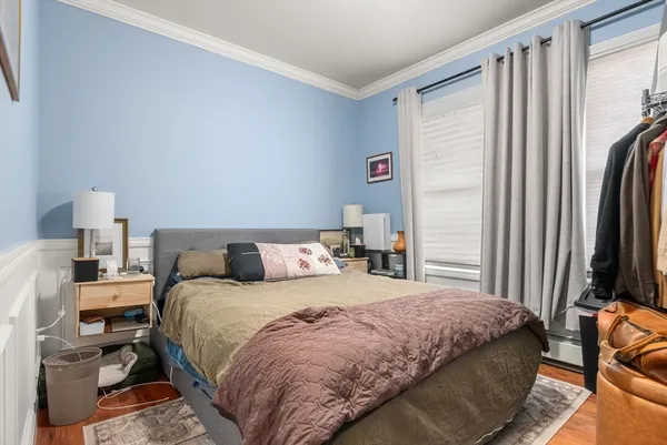 a bedroom with a bed and a flat tv screen on a dresser