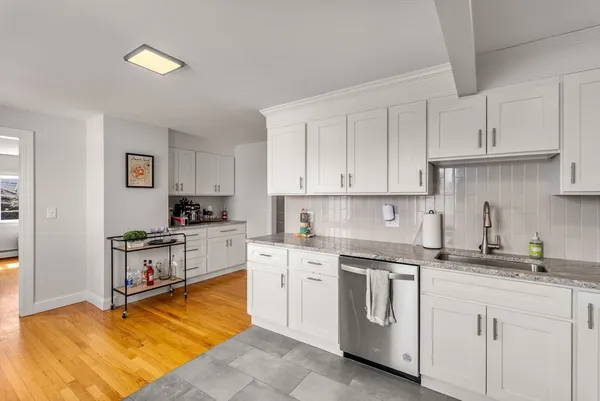 a kitchen with white cabinets appliances and a sink
