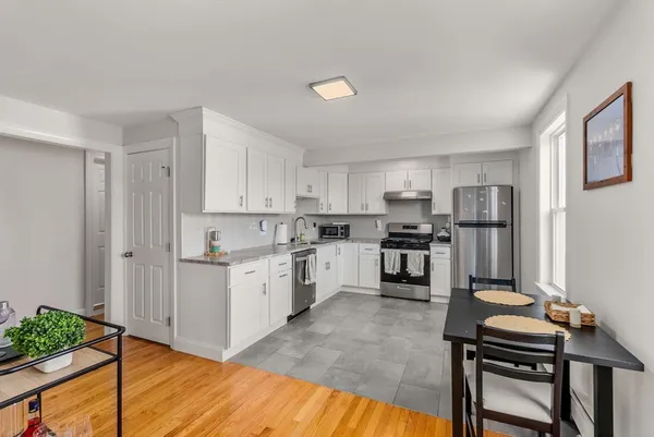 a kitchen with white cabinets and stainless steel appliances