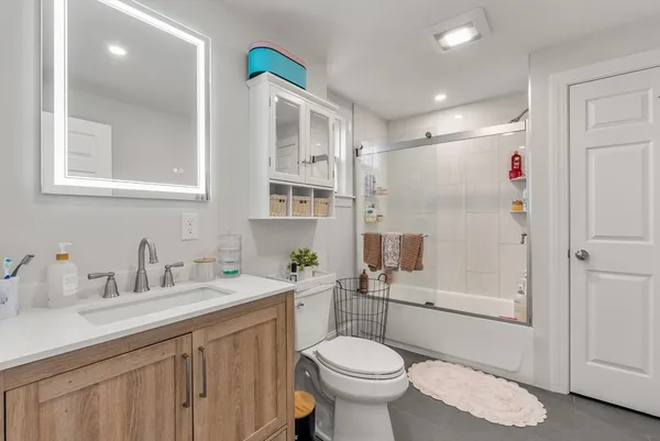 a bathroom with a sink toilet a mirror and shower