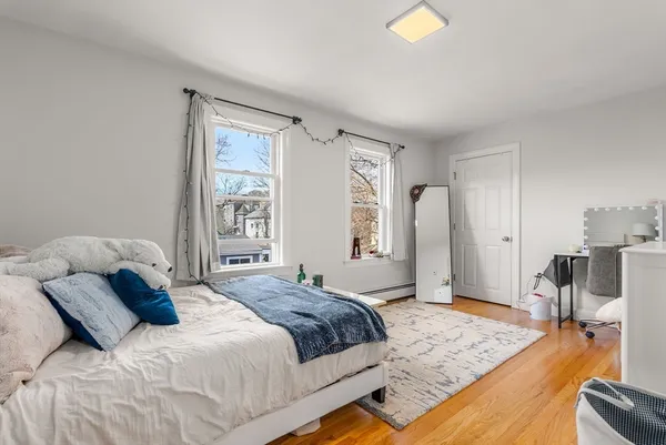a bedroom with a bed and wooden floor