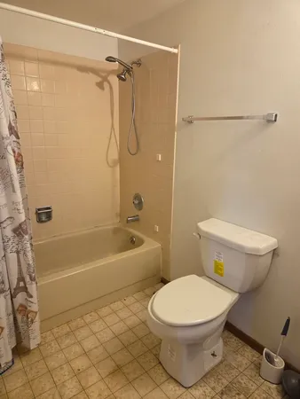 a bathroom with a toilet and a shower