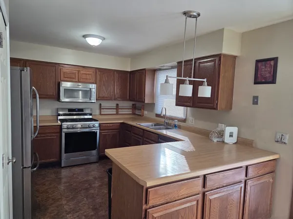 a kitchen with granite countertop a sink stove and refrigerator