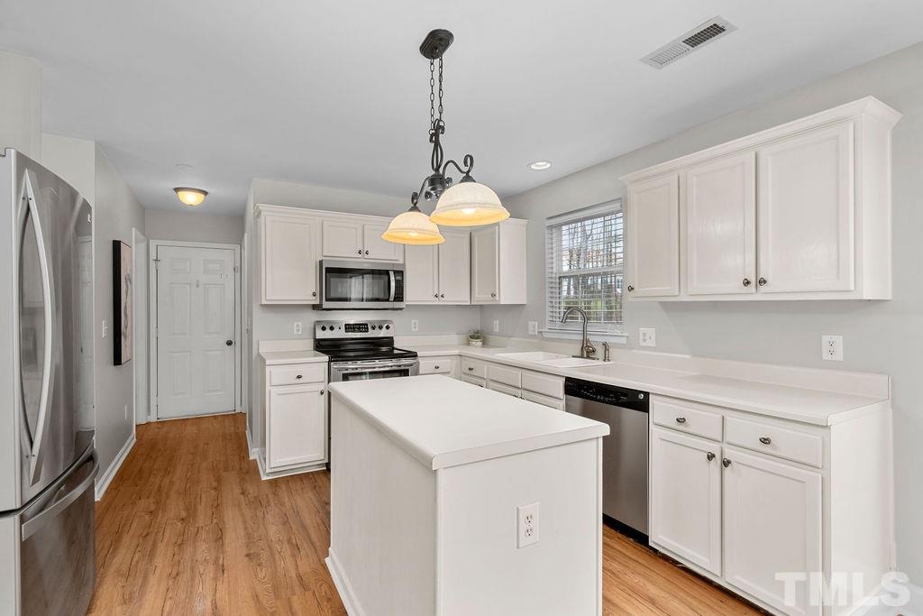 6823 Edwell Court Raleigh, NC 27617 - Photo 8 of 30 a kitchen with a sink stainless steel appliances and white cabinets