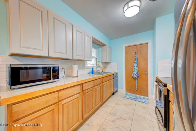 a kitchen with stainless steel appliances granite countertop a refrigerator and a stove top oven