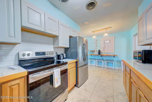 a kitchen with stainless steel appliances granite countertop a stove and a refrigerator