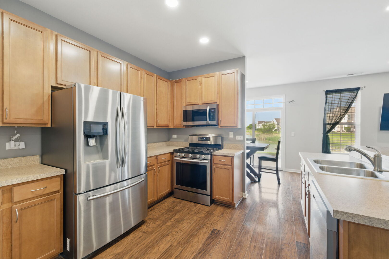 15340 Kenmare Circle Manhattan, IL 60442 - Photo 6 of 19 a kitchen with stainless steel appliances granite countertop a refrigerator microwave and stove top oven