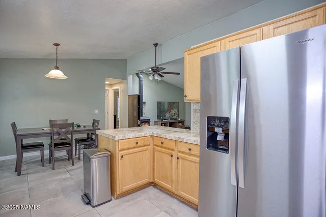 a kitchen with stainless steel appliances granite countertop a sink stove refrigerator and cabinets