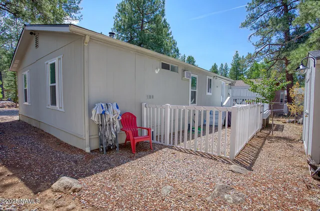 a view of a small yard in front of a house with wooden fence