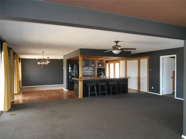 a kitchen with stainless steel appliances granite countertop a sink a stove and a wooden cabinets