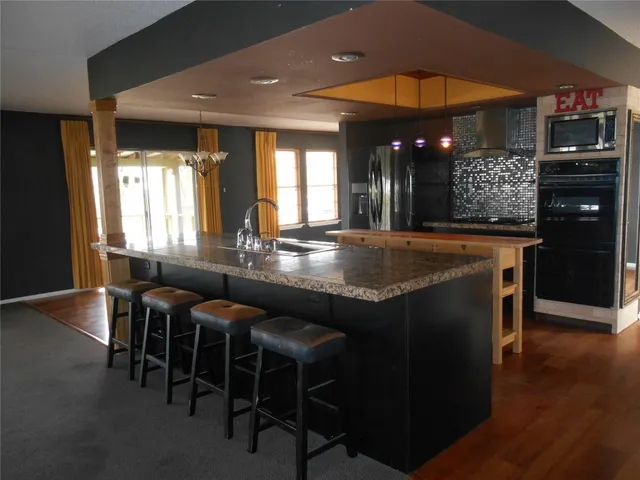 a view of a dining room with furniture a chandelier and wooden floor