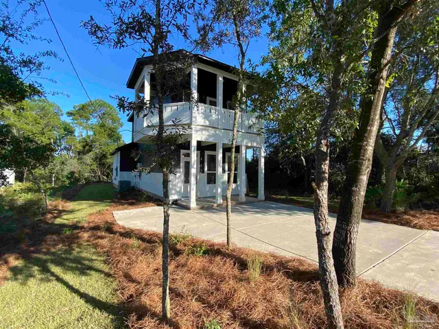 a yellow house with trees in front of it
