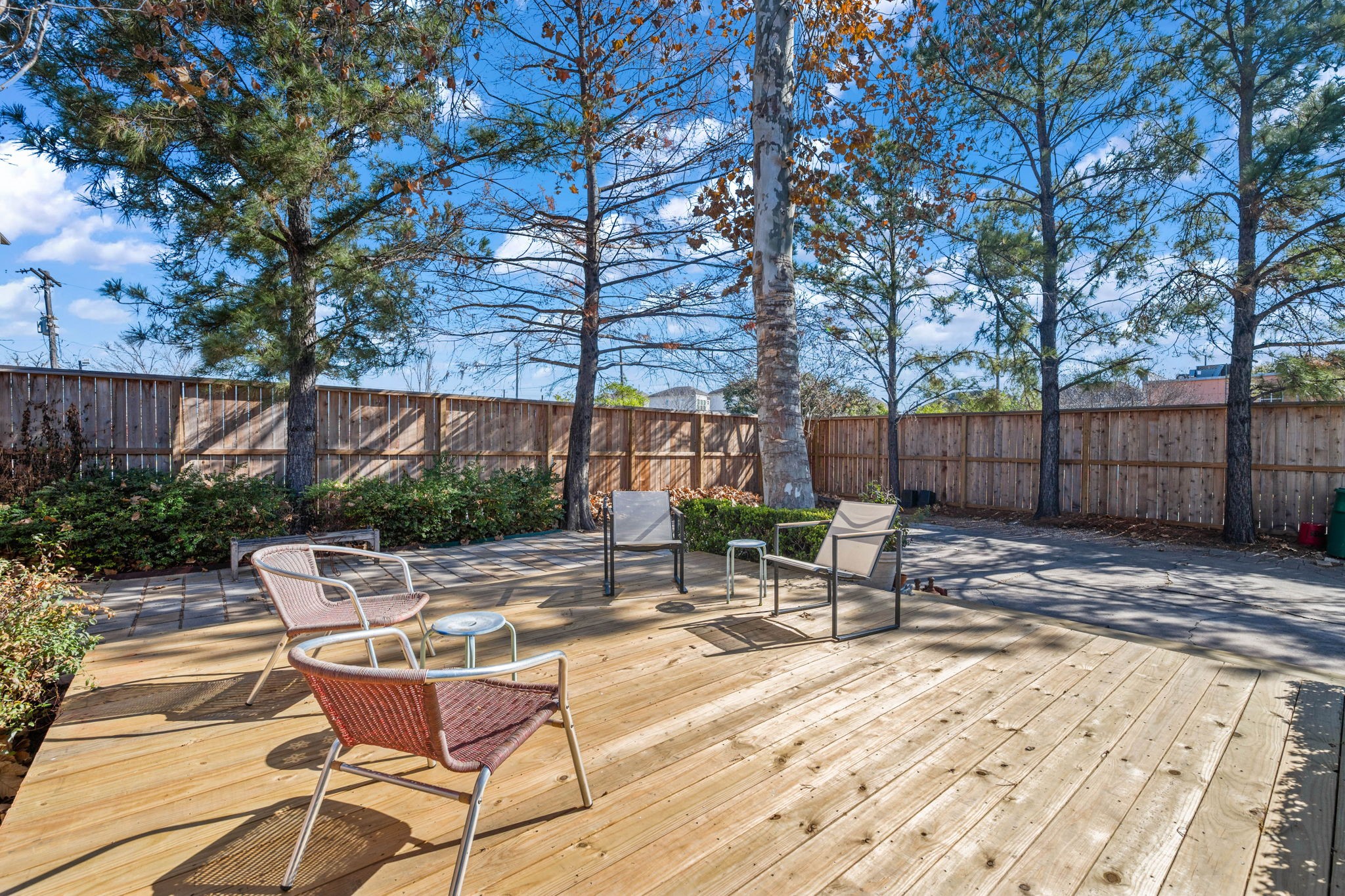 1831 Palm Street Houston, TX 77004 - Photo 20 of 27 Generous backyard with wooden deck for ample seating or entertaining. Surrounded by mature trees and a nice wooden fence, offering a private and serene outdoor retreat.