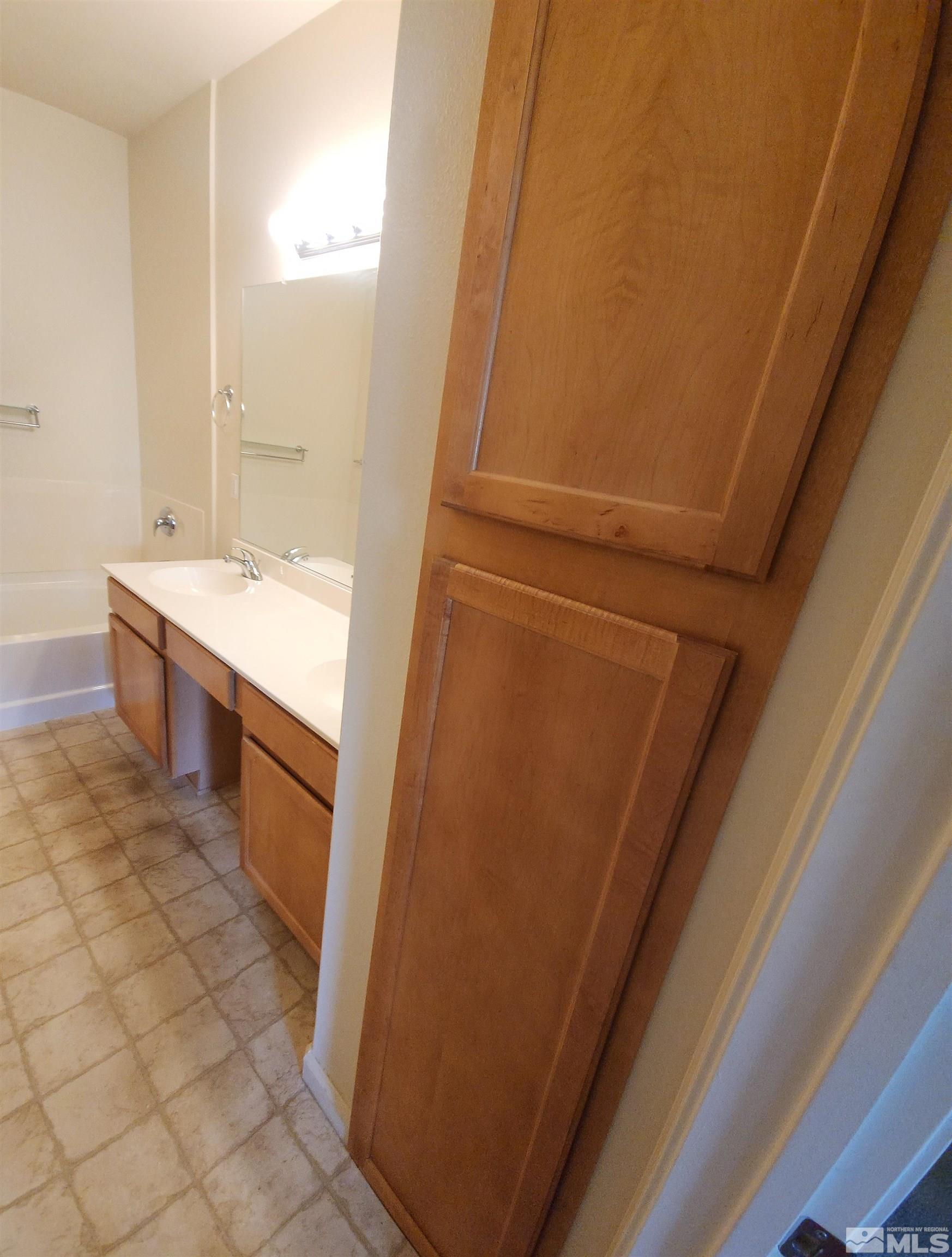 9050 Double R Boulevard, Unit 1124 Reno, NV 89521 - Photo 25 of 40 a bathroom with a sink a mirror and a bathtub
