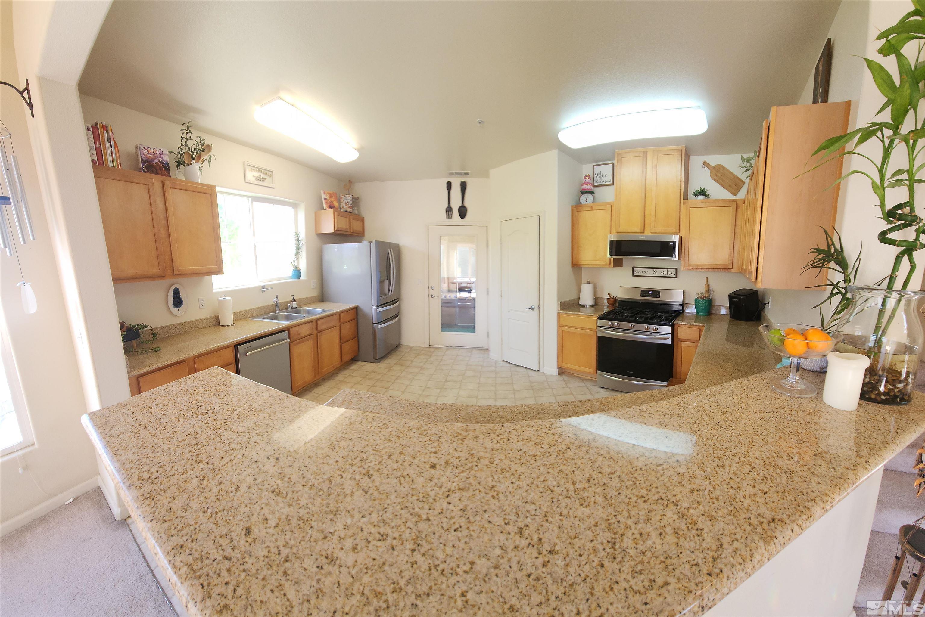 9050 Double R Boulevard, Unit 1124 Reno, NV 89521 - Photo 3 of 40 a large kitchen with kitchen island a sink stove and refrigerator